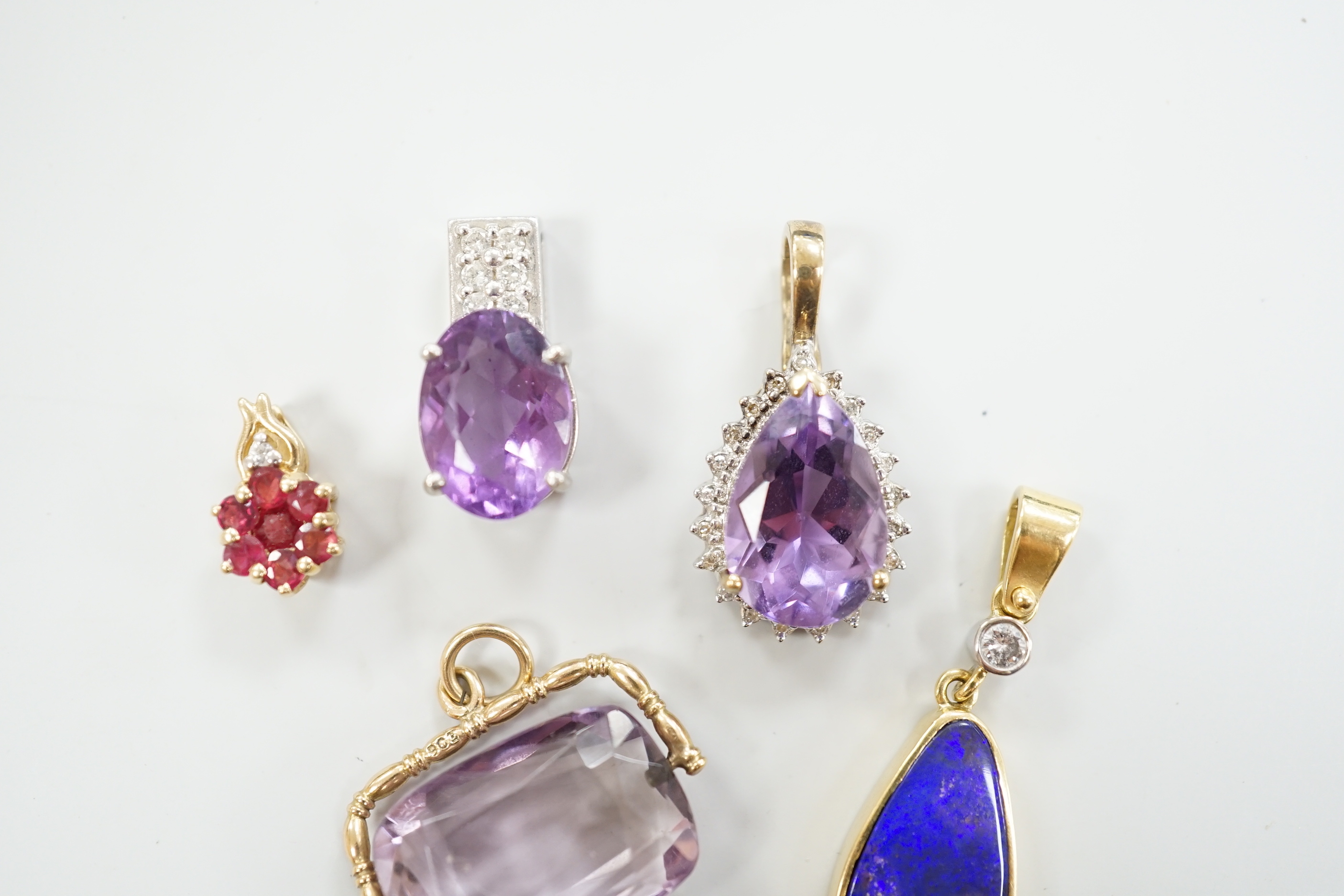 A white metal, stamped PT900, amethyst and diamond cluster set pendant, 18mm, gross weight 5.5 grams and four other pendants including three 9ct and gem set and a yellow metal and simulated opal and diamond, gross 13 gra